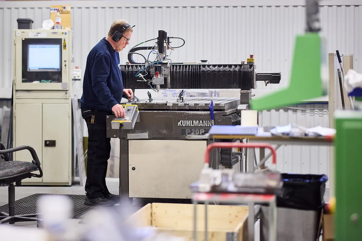Operatör vid en CNC-fräs i Aluscreens verkstad i Västerås